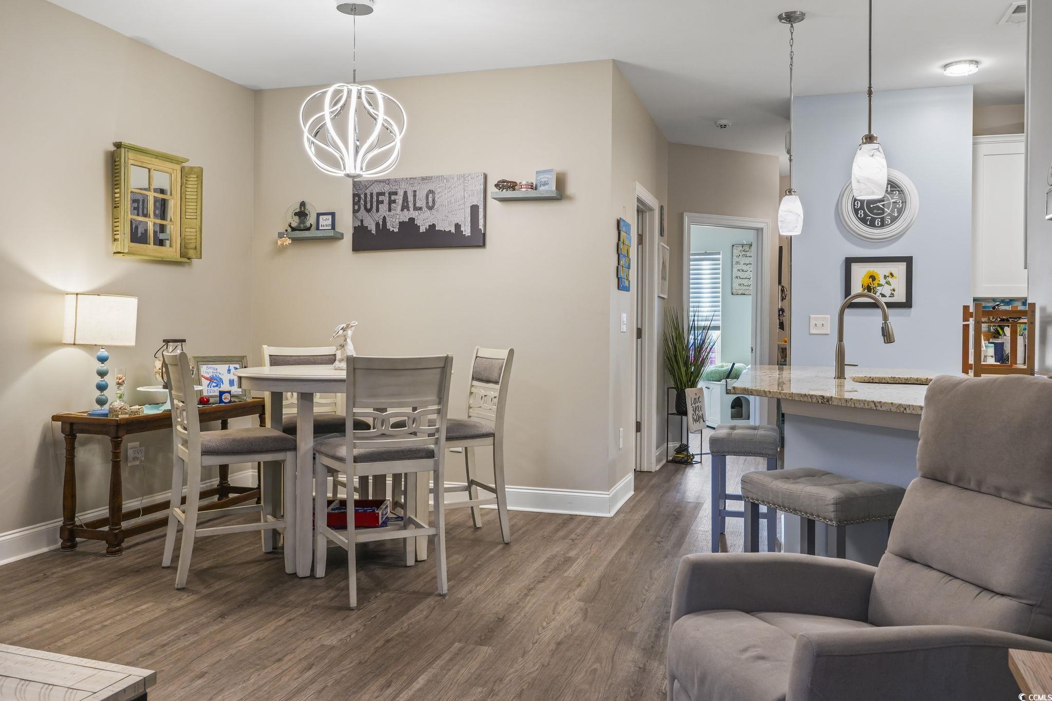 124 Birch N Coppice Drive, Unit 3 Surfside Beach, SC 29575 - Photo 11 of 40 Dining space with dark wood-type flooring and a chandelier