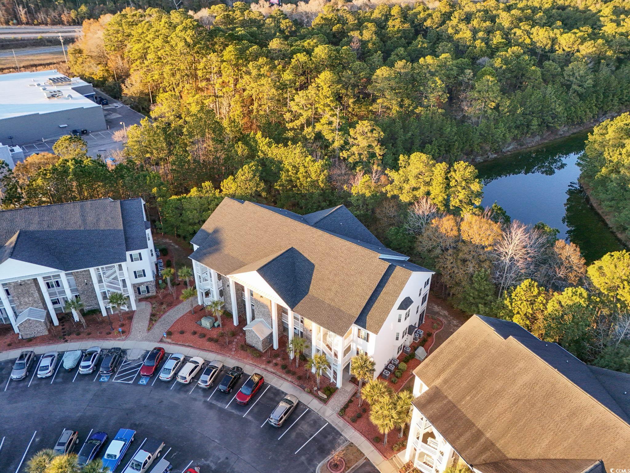 124 Birch N Coppice Drive, Unit 3 Surfside Beach, SC 29575 - Photo 2 of 40 Aerial view of a nearby body of water and a heavily wooded area