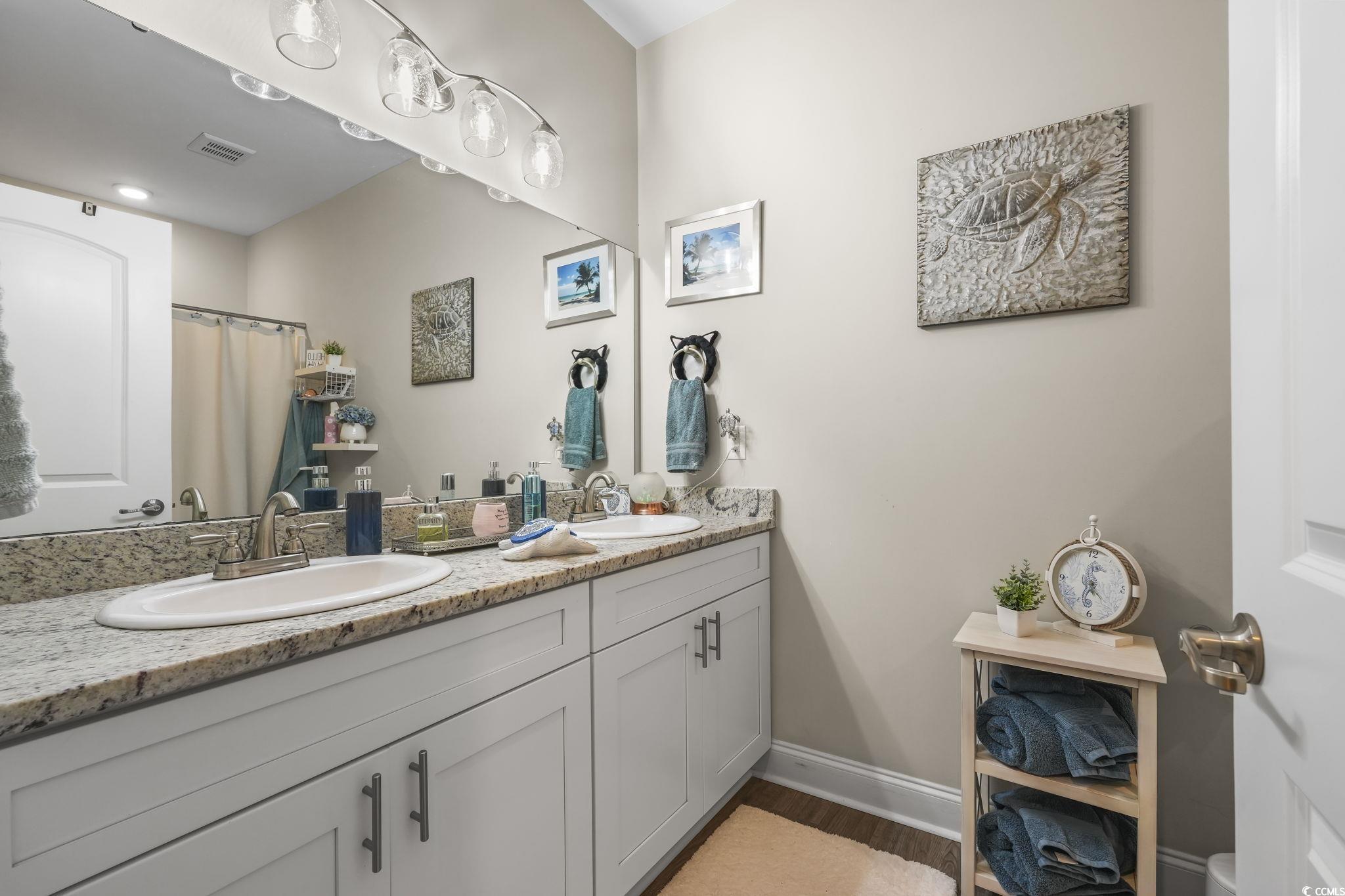 124 Birch N Coppice Drive, Unit 3 Surfside Beach, SC 29575 - Photo 21 of 40 Full bathroom with double vanity, curtained shower, and dark wood-style floors
