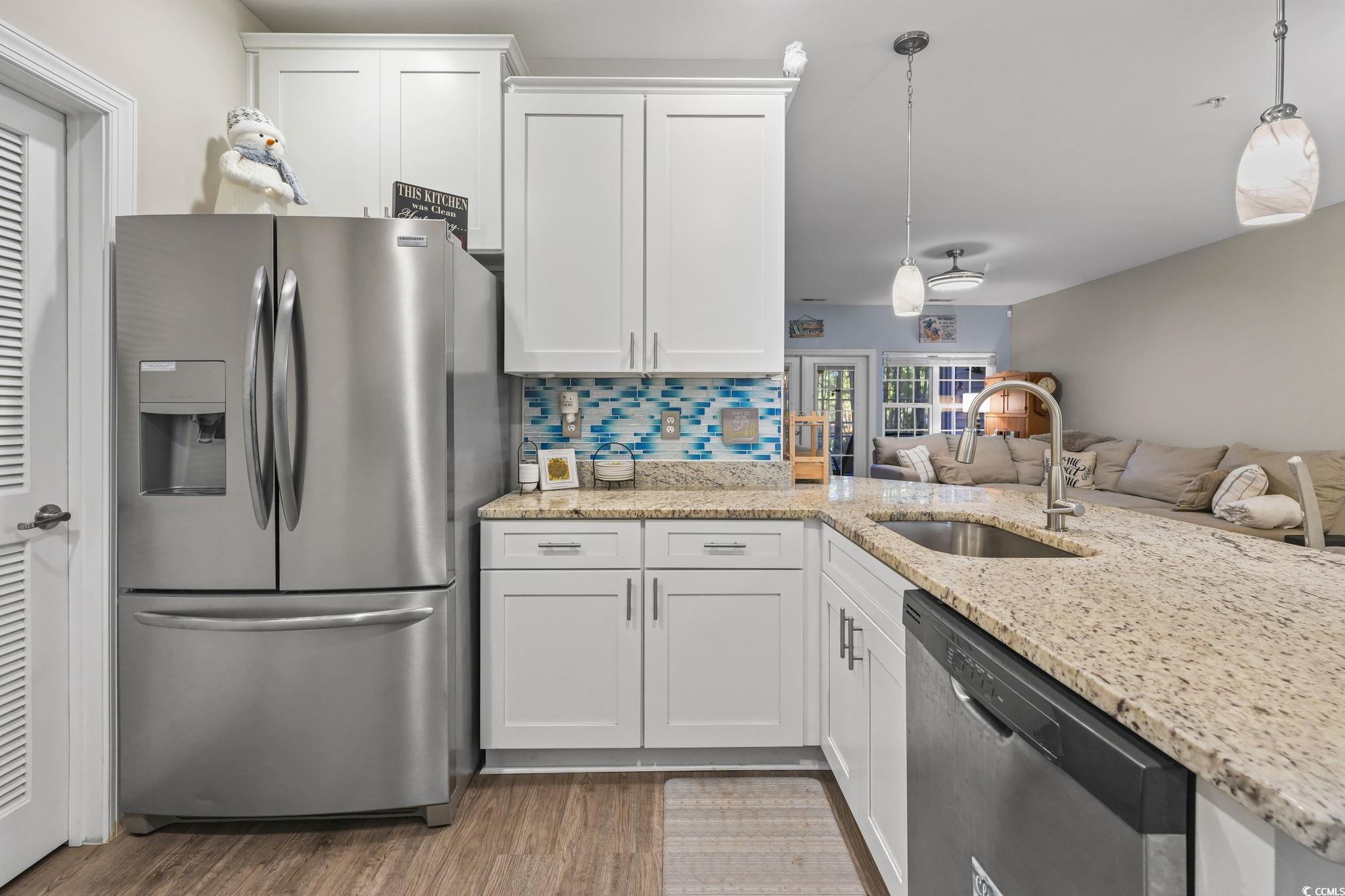 124 Birch N Coppice Drive, Unit 3 Surfside Beach, SC 29575 - Photo 4 of 40 Kitchen with appliances with stainless steel finishes, white cabinetry, and light stone countertops