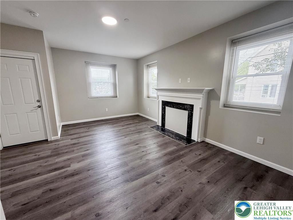 801 West Broad Street, Unit 1 Bethlehem, PA 18018 - Photo 7 of 31 an empty room with wooden floor fireplace and windows