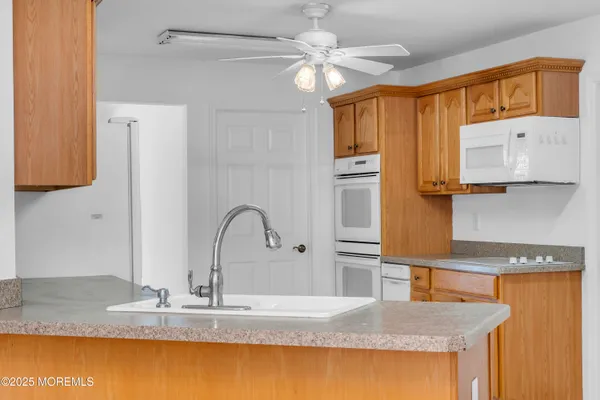 a kitchen with stainless steel appliances granite countertop a sink a refrigerator and a granite counter tops