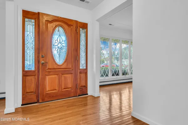 a view of a hallway with wooden floor and a window