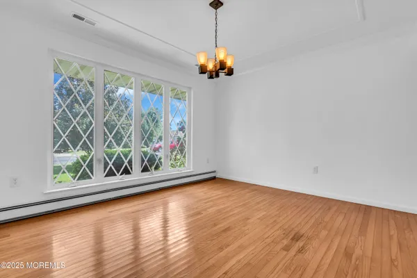 a view of a room with window chandelier and wooden floor