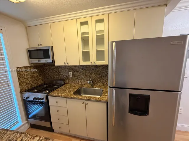 a kitchen with a sink a stove and a refrigerator