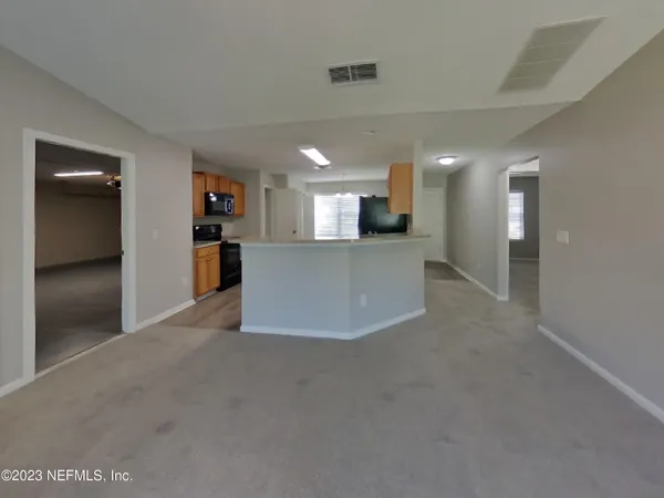 a view of a kitchen and a refrigerator in a room
