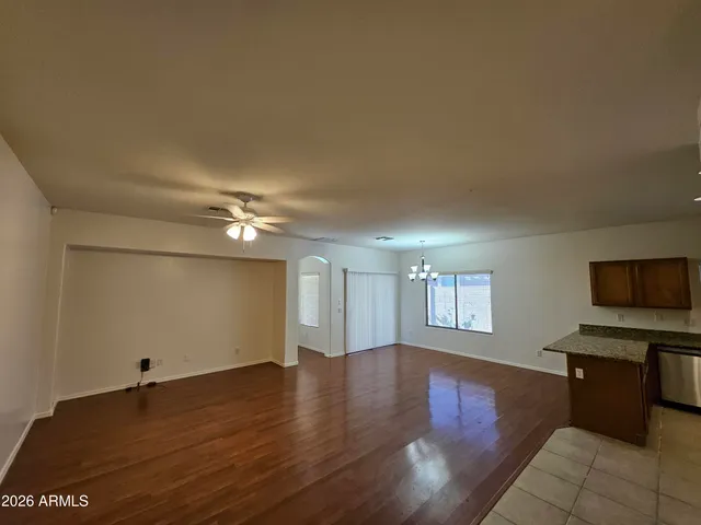 a view of a livingroom with furniture a ceiling fan and wooden floor