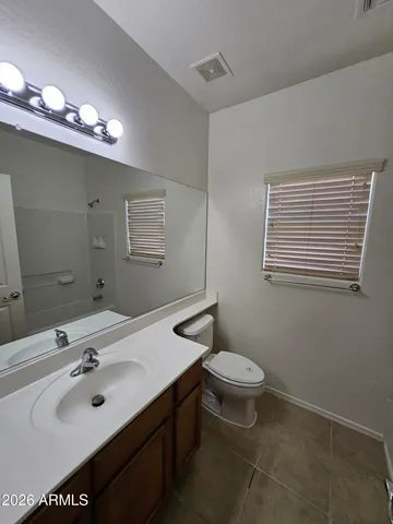 a bathroom with a sink a toilet a mirror and shower
