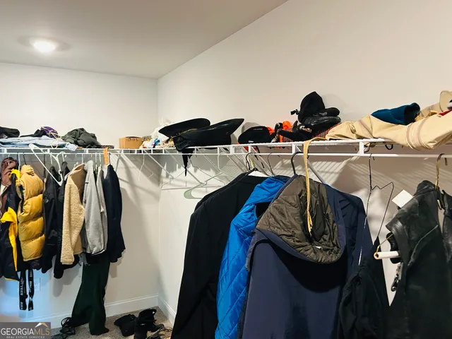 a view of walk in closet with clothes and shoes