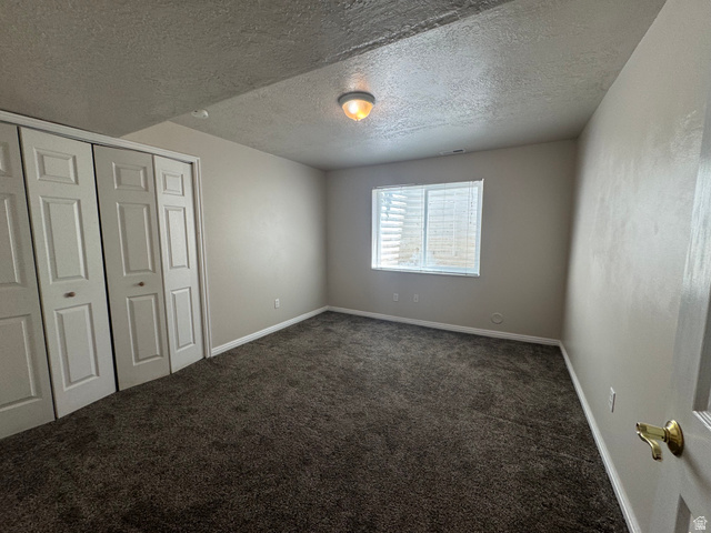 88 Canterbury Lane Logan, UT 84321 - Photo 30 of 37 Wall-to-wall carpeting in a neutral tone, complemented by light-colored walls and a textured ceiling