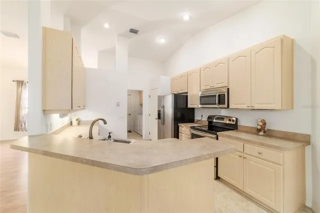 a kitchen with stainless steel appliances granite countertop a stove top oven a sink and dishwasher a refrigerator with white cabinets