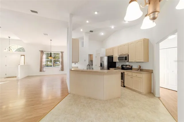 a kitchen with stainless steel appliances granite countertop a sink a stove and a refrigerator