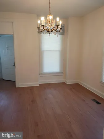 a view of a chandelier in big room and wooden floor