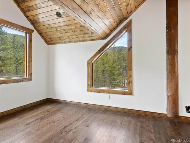 a view of empty room with wooden floor