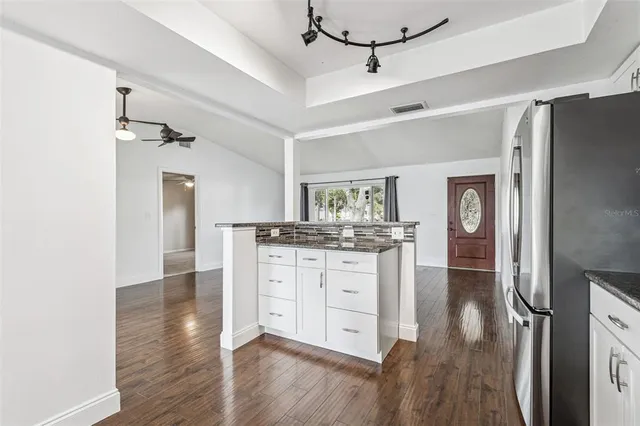 a kitchen with wooden floors and white cabinets