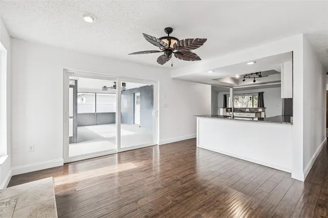 a view of a living room and kitchen with a ceiling fan