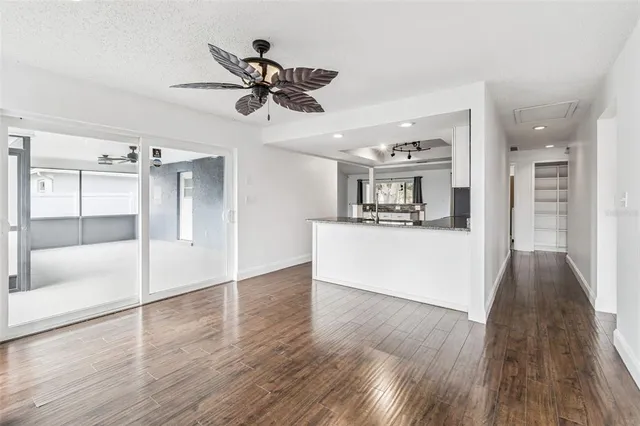 a view of a living room and kitchen with wooden floor