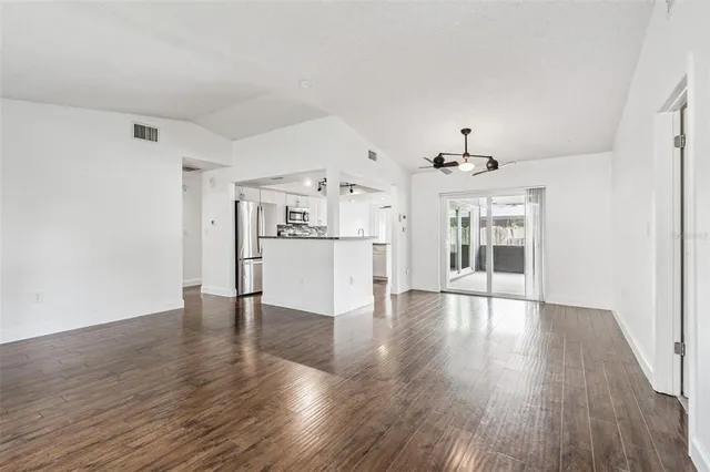 a view of a kitchen with wooden floor and a refrigerator