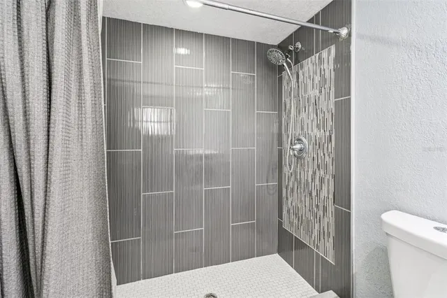 a bathroom with a shower and toilet