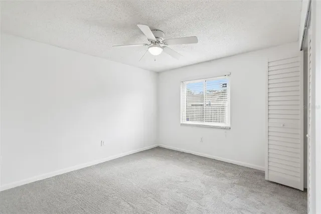 an empty room with a window and a fan