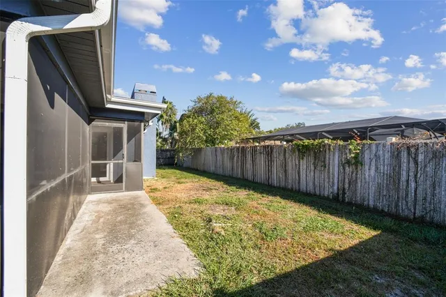 a view of backyard with wooden fence