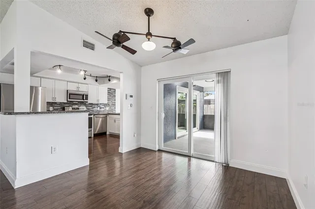 a view of a kitchen with a refrigerator a microwave and wooden floor
