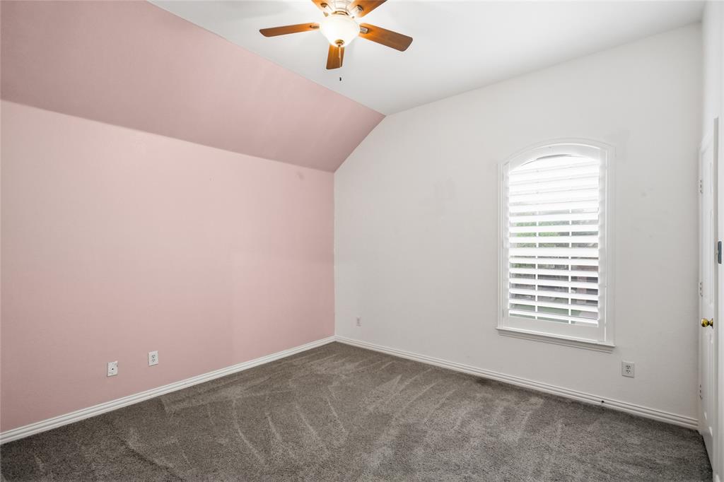 5201 Geode Lane McKinney, TX 75072 - Photo 27 of 37 Good size secondary bedroom with vaulted ceilings and pretty blush colored accent wall.