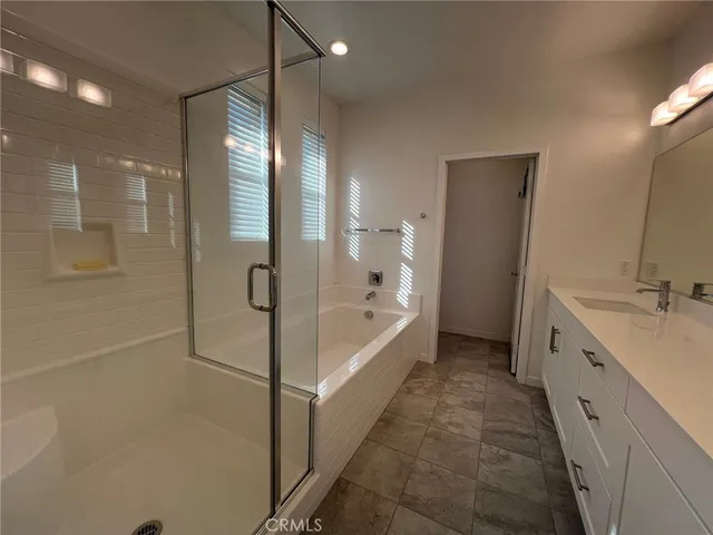 a bathroom with a double vanity sink a mirror and a bathtub