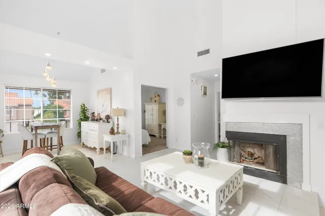 a living room with furniture a flat screen tv and a fireplace