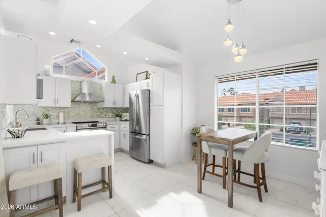 a kitchen with refrigerator and chairs