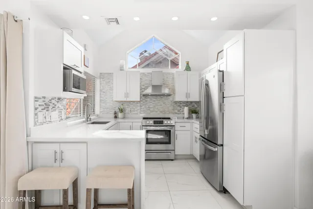 a kitchen with stainless steel appliances granite countertop a refrigerator sink and stove