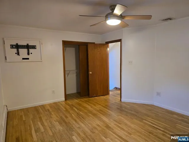 a view of empty room with ceiling fan and window