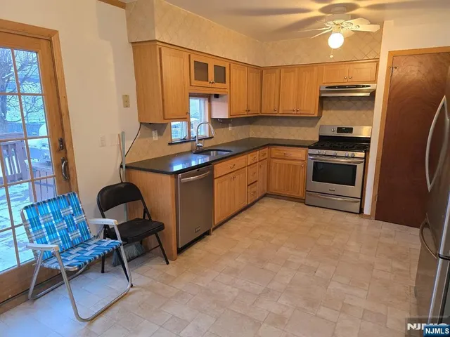 a kitchen with stainless steel appliances granite countertop a stove refrigerator and a sink