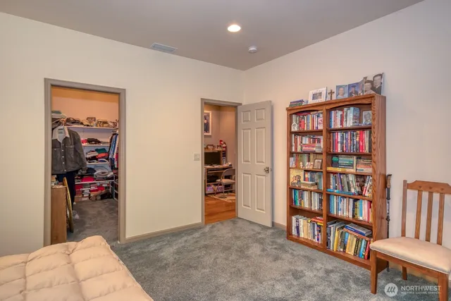 a bedroom with furniture and a book shelf