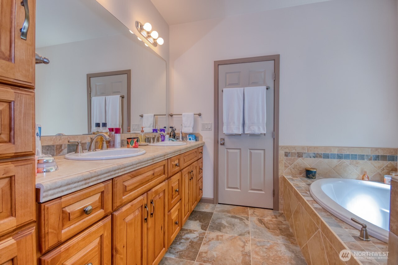 163 Prawn Road Port Angeles, WA 98363 - Photo 17 of 40 a bathroom with a granite countertop sink a bathtub a mirror and vanity