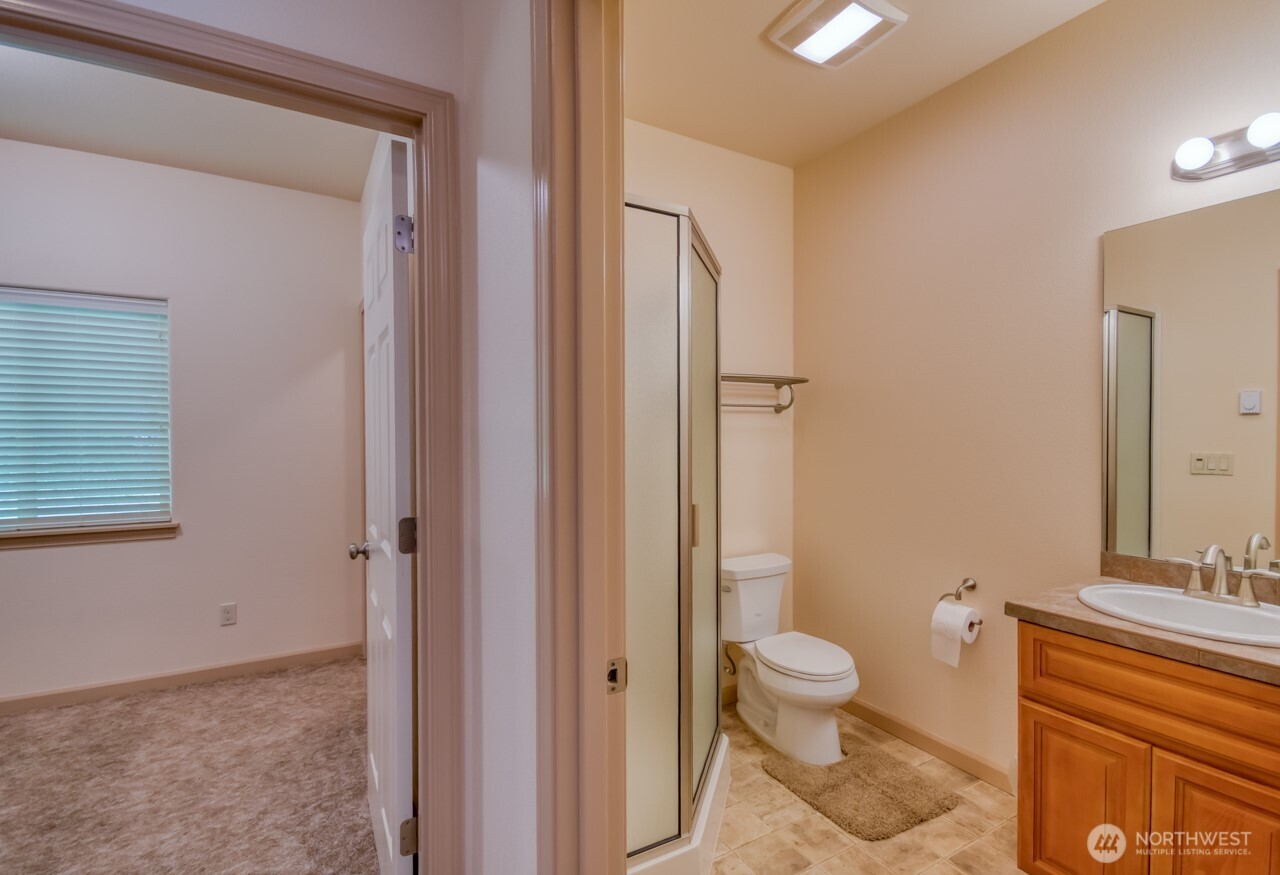 163 Prawn Road Port Angeles, WA 98363 - Photo 32 of 40 a bathroom with a granite countertop toilet a sink and a mirror