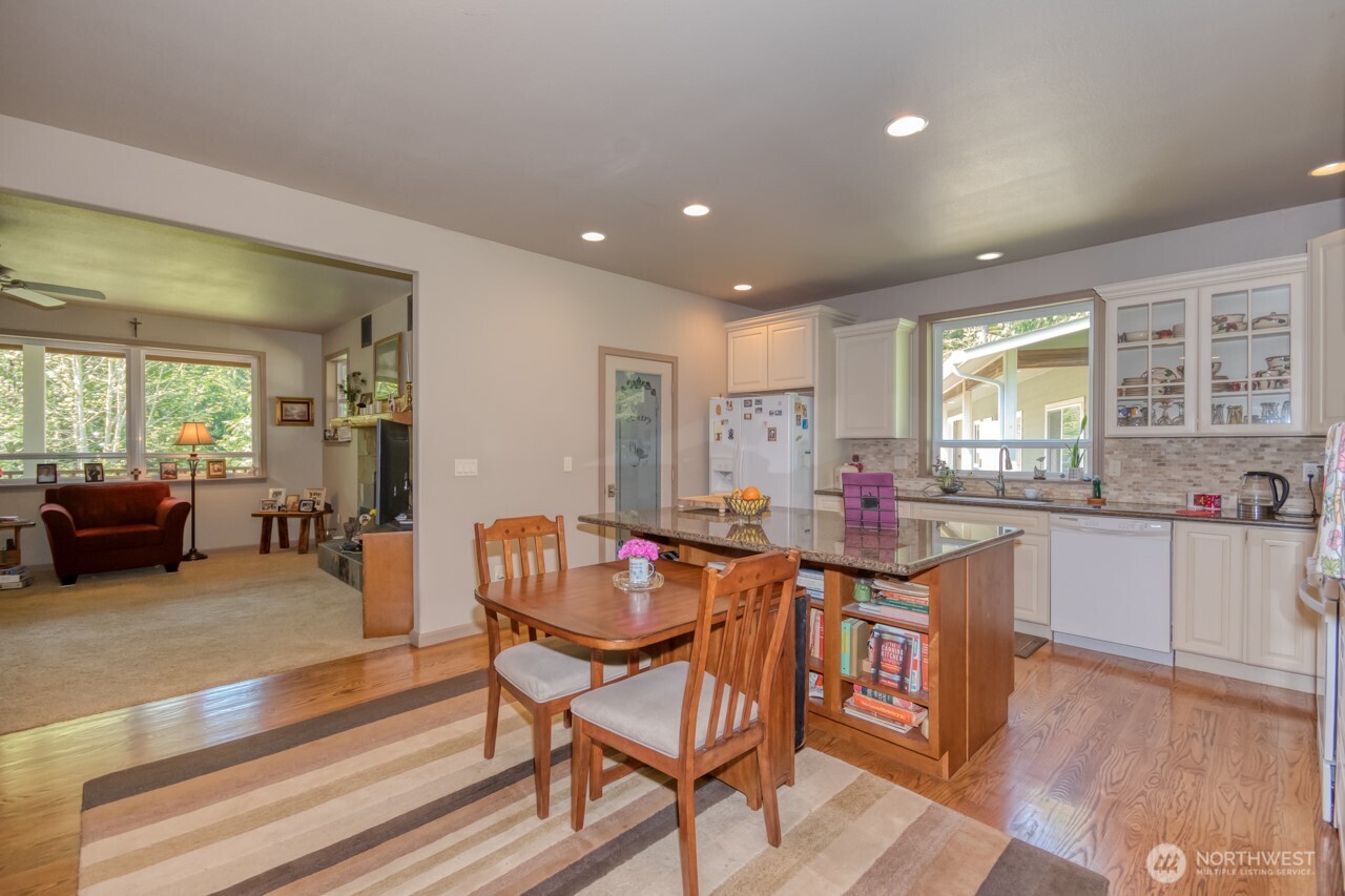 163 Prawn Road Port Angeles, WA 98363 - Photo 7 of 40 a dining hall with stainless steel appliances granite countertop a stove a sink a dining table and chairs with wooden floor