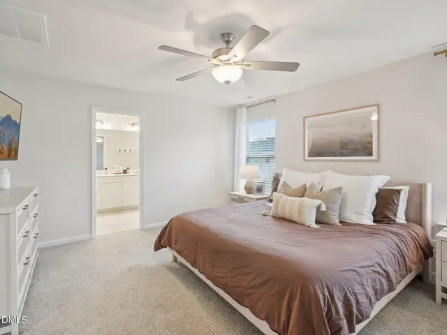 a bedroom with a large bed and a ceiling fan