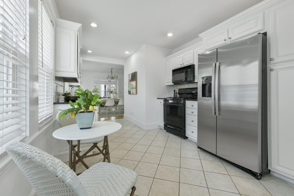 64 Parmenter Road, Unit 1 Waltham, MA 02453 - Photo 11 of 25 a kitchen with stainless steel appliances granite countertop a refrigerator and a stove top oven