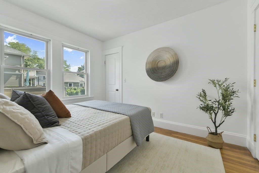 64 Parmenter Road, Unit 1 Waltham, MA 02453 - Photo 12 of 25 a bedroom with a bed and a potted plant