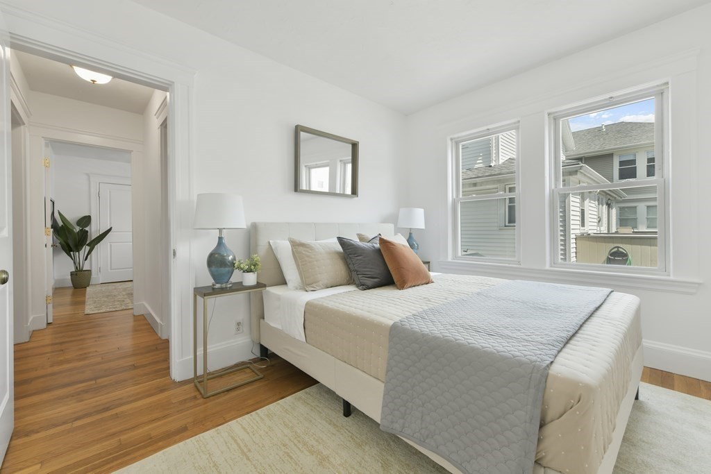 64 Parmenter Road, Unit 1 Waltham, MA 02453 - Photo 13 of 25 a bedroom with a bed and a potted plant