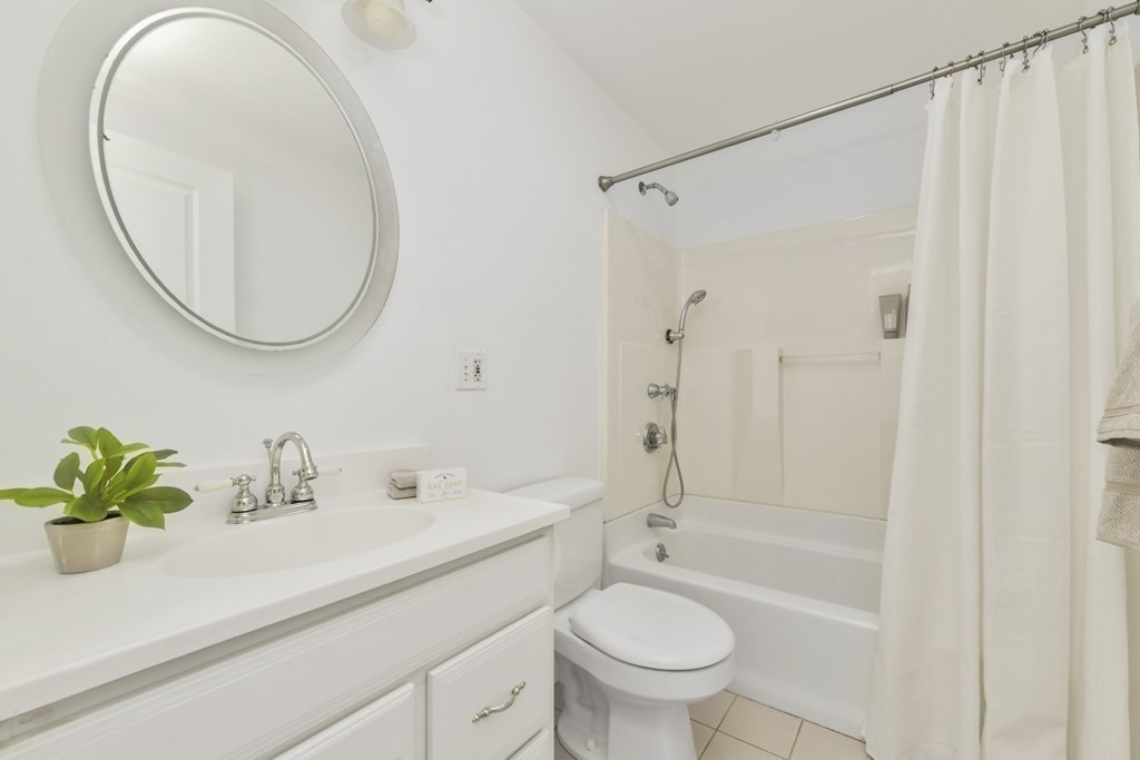 64 Parmenter Road, Unit 1 Waltham, MA 02453 - Photo 16 of 25 a bathroom with a sink a toilet and a mirror