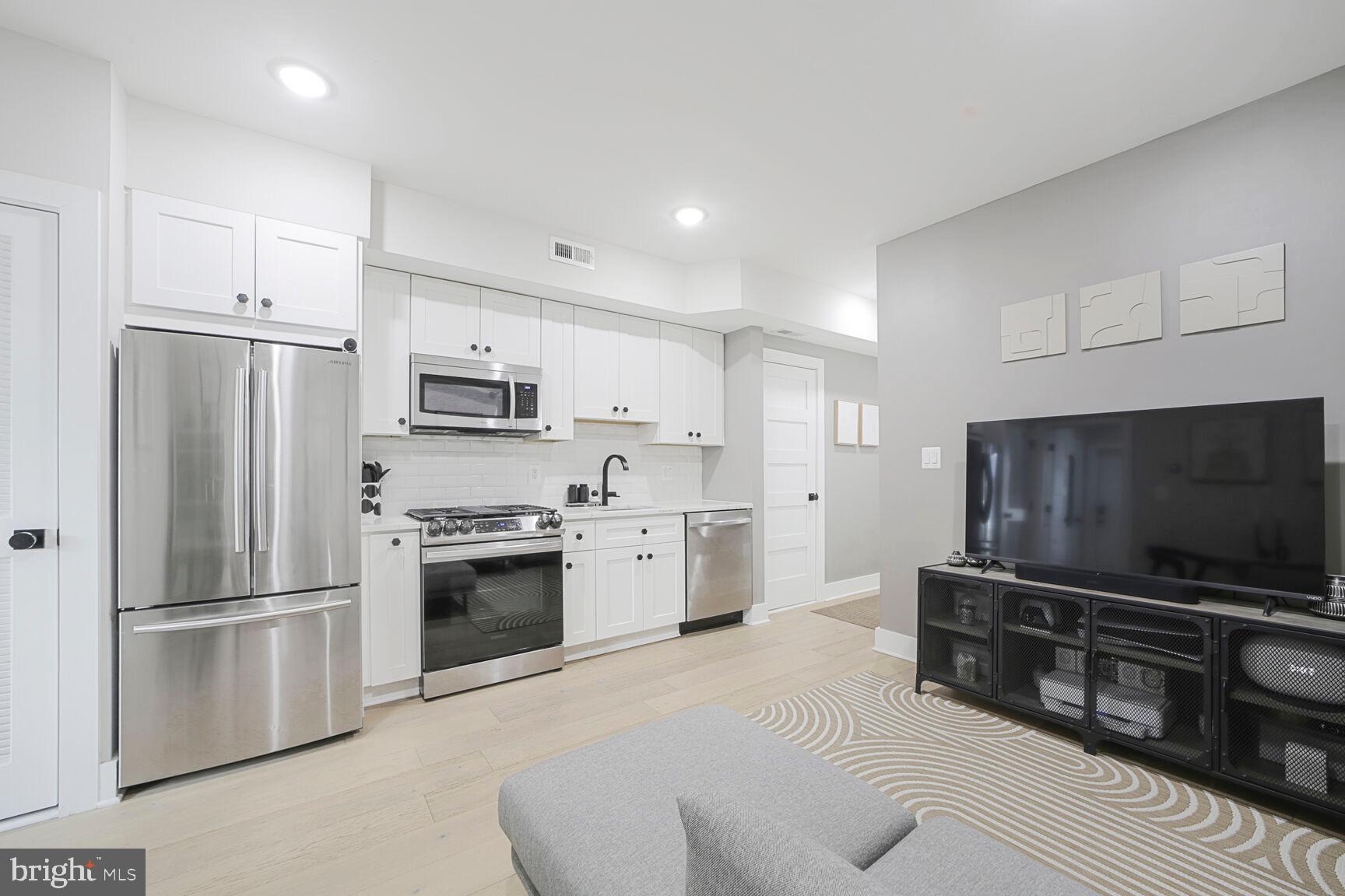 1144 Owen Place Northeast, Unit 1 Washington, DC 20002 - Photo 12 of 27 a kitchen with stainless steel appliances a refrigerator a stove a microwave and cabinets