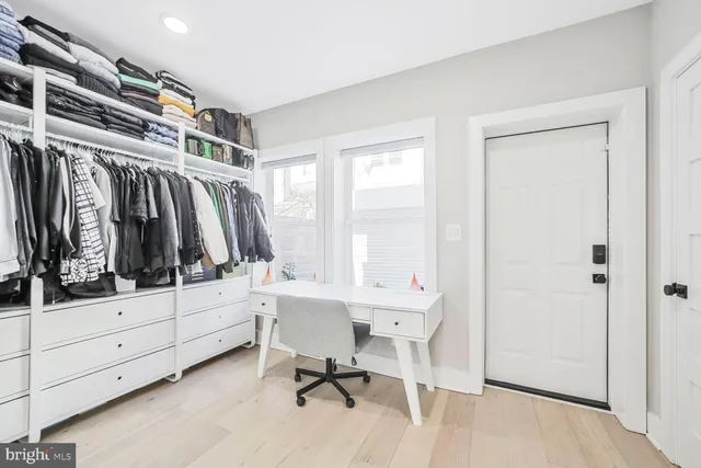 a view of walk in closet with clothes and shoes