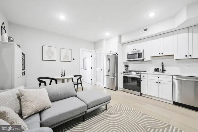 a living room with furniture white walls and white appliances