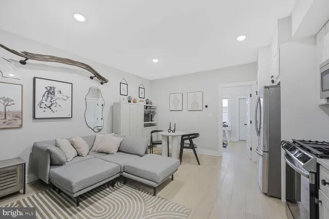 a living room with furniture and a refrigerator