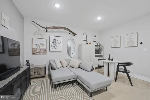 a living room with furniture and a dining table with wooden floor