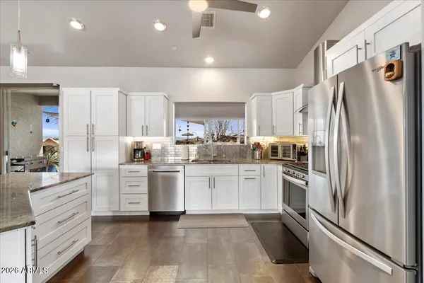 a kitchen with white cabinets and stainless steel appliances