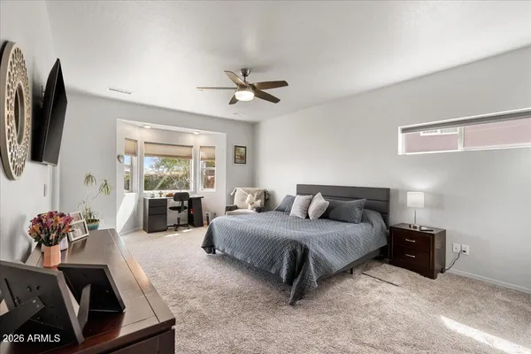a bedroom with a bed couch and flat screen tv