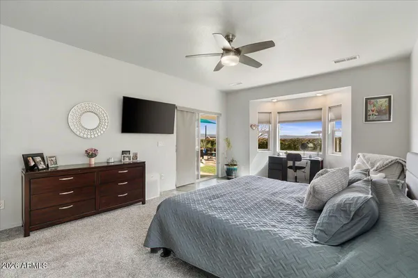 a bedroom with a bed and a flat tv screen on dresser